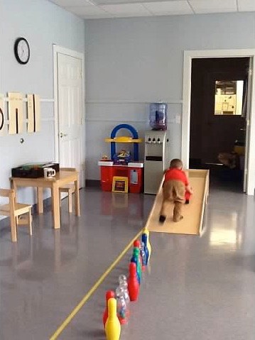 Child in an indoor obstacle course engaging in motor planning exercise. 